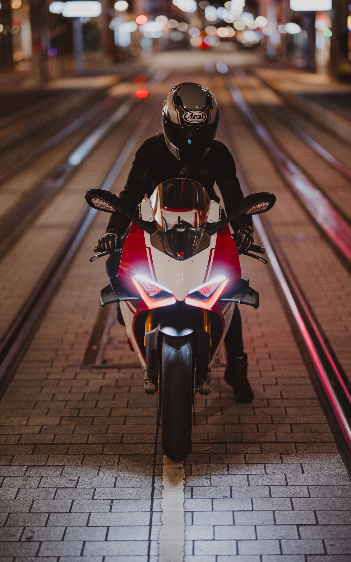 Female rider on a red Ducati at twilight
